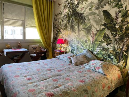 a bedroom with a bed with a tropical wallpaper at L'Etoile du Sud in Tours