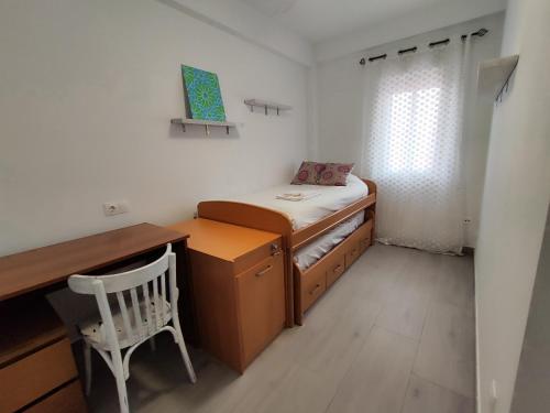 a small room with a bed and a desk and a chair at La casa del mercado in Córdoba