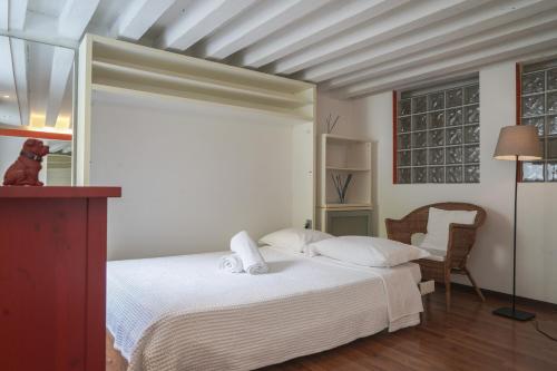 1 dormitorio con 1 cama blanca y 1 silla en Melusina Homes en Venecia