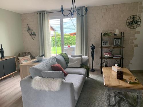 a living room with a couch and a table at Villa au coeur de la vallée in Thyez