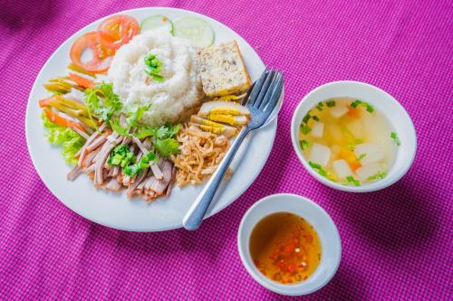 um prato de comida com arroz e uma tigela de sopa em Nhà Hàng Khách Sạn Hòa Bình 2 em Long Xuyên