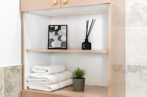 a pile of towels on a shelf in a bathroom at Skyline Sunset View -XCity Tower - By OpenHouse apartments in Timişoara