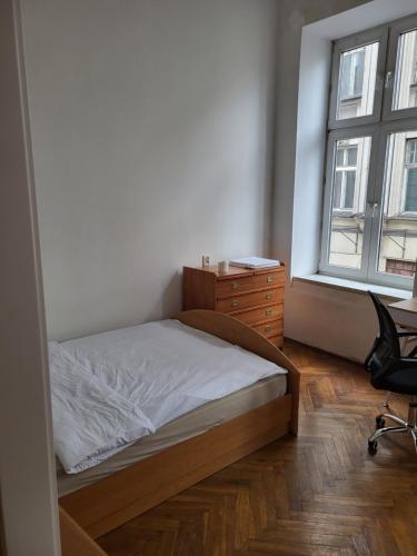 a bedroom with a bed and a dresser and a window at Agnieszki Room nr 2 in Krakow