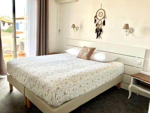 a bedroom with a large bed with a headboard at Hotel Lou Marquès in Saintes-Maries-de-la-Mer