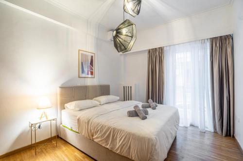 a bedroom with a bed with a teddy bear on it at Modern Pagrati - Greecing in Athens