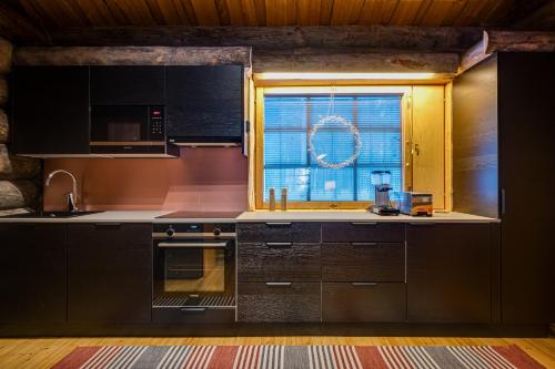 a kitchen with black cabinets and a window at Villa Poronperä in Kuusamo