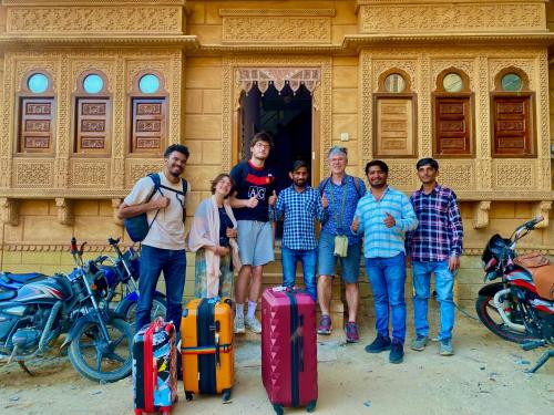 een groep mensen die voor een gebouw met bagage staan bij Hotel Murad Haveli Jaisalmer in Jaisalmer