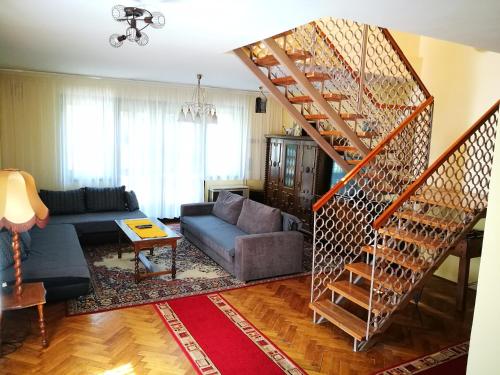 a living room with a spiral staircase and a couch at 3 Tó Sziki Szálló in Szeged