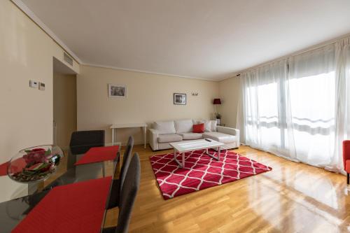 ein Wohnzimmer mit einer weißen Couch und einem roten Teppich in der Unterkunft Cituspace Las Tablas Azofra in Madrid