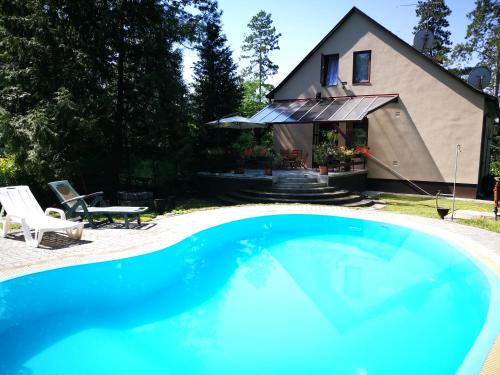 una gran piscina azul frente a una casa en 3 Tó Sziki Szálló, en Szeged