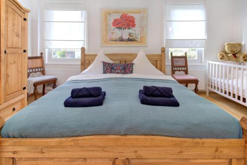 Un dormitorio con una gran cama de madera con almohadas moradas en Familienglück im Schwarzwaldhaus mit Schlossblick, en Neuenbürg