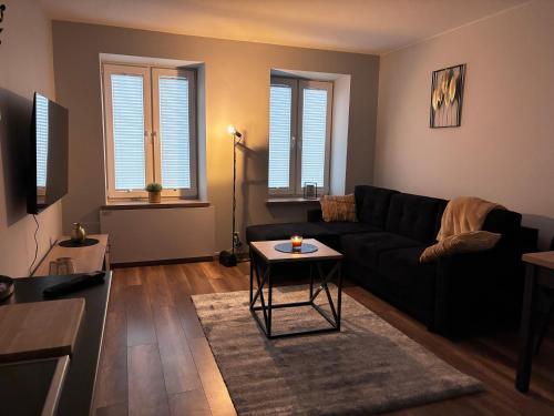 a living room with a black couch and a table at Apartament w centrum in Łódź