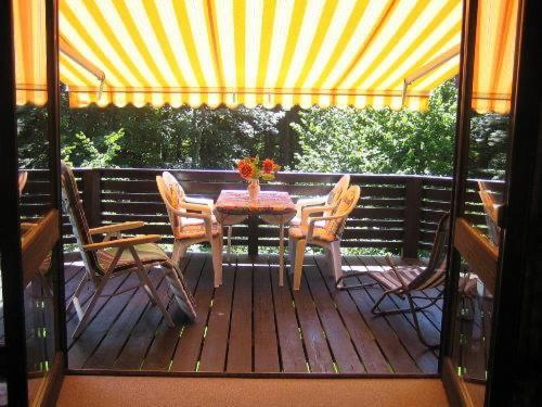 una terraza de madera con mesa y sillas. en Ferienhaus Amrhein, en Siegsdorf