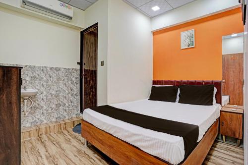 a bedroom with a bed and a sink at Super OYO Hotel Orange in Surat