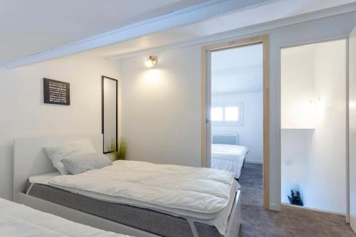 une chambre avec un grand lit et un miroir dans l'établissement Chez Marlène - Superbe appartement duplex à proximité des plages, au Grau-du-Roi