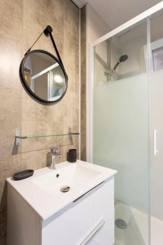 une salle de bain avec un lavabo blanc et un miroir dans l'établissement Chez Marlène - Superbe appartement duplex à proximité des plages, au Grau-du-Roi