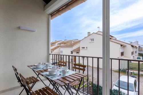 une table et des chaises sur un balcon avec vue dans l'établissement Chez Marlène - Superbe appartement duplex à proximité des plages, au Grau-du-Roi