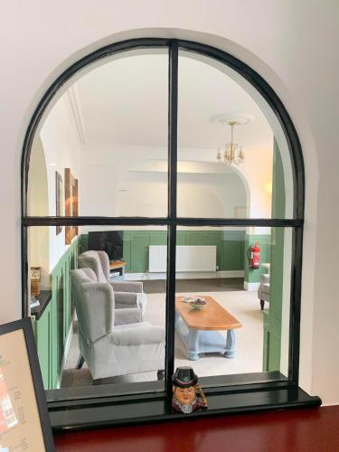 a room with an arched window with a living room at Abbots Mead Hotel in Shrewsbury