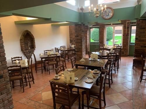 a dining room with tables and chairs and a chandelier at Abbots Mead Hotel in Shrewsbury