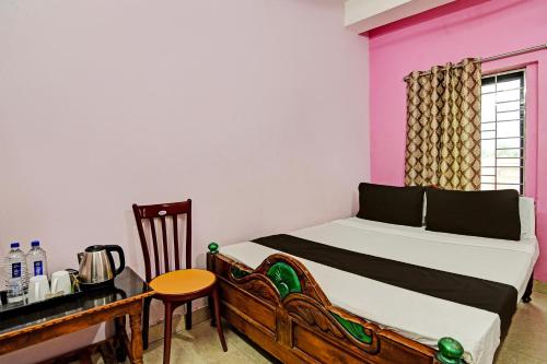 a bedroom with a bed and a table and a desk at OYO Mahalaxmi lodge in Cuttack