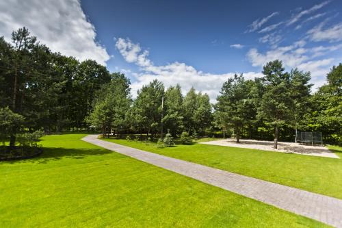a walkway in a park with green grass and trees at Mercure Wiazowna Brant in Wiązowna
