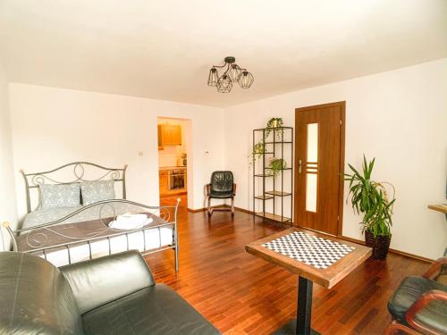 una sala de estar con una cama y una mesa en Apartament przy parku, en Toruń