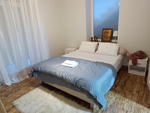 een slaapkamer met een bed met twee handdoeken erop bij flora's memories appartment in Kavala