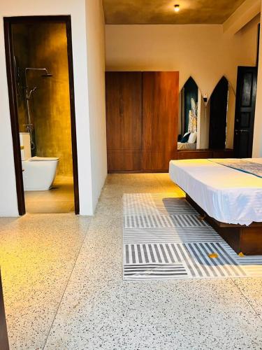 a bedroom with a bed and a bathroom with a tub at The Kheak in Weligama