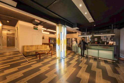 a person standing in a lobby with a couch at Hotel Bilbi in Bilbao