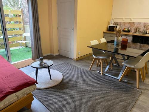 une cuisine et une salle à manger avec une table et des chaises dans l'établissement Appartement lumineux rez-de-chaussée prox GARE, à Cambrai