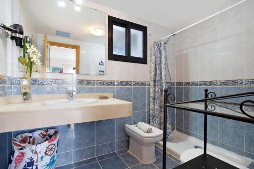 a bathroom with a sink and a toilet and a mirror at La Casa Blanca in Corralejo