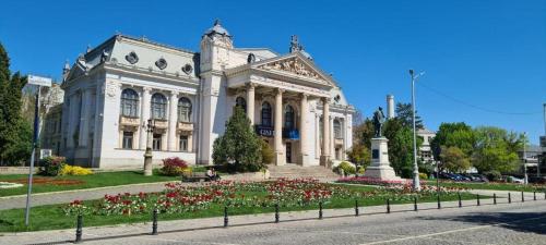 a large white building with flowers in front of it at Great Exodus - Iasi City Center in Iaşi