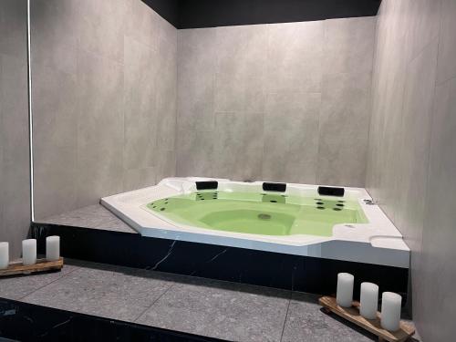 La salle de bains est pourvue d'une baignoire verte. dans l'établissement Wyspa Solna Apartament LUX, à Kołobrzeg
