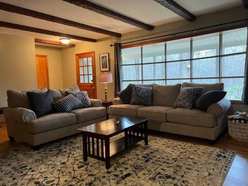 a living room with two couches and a coffee table at Mountain Road Lodge in Tannersville