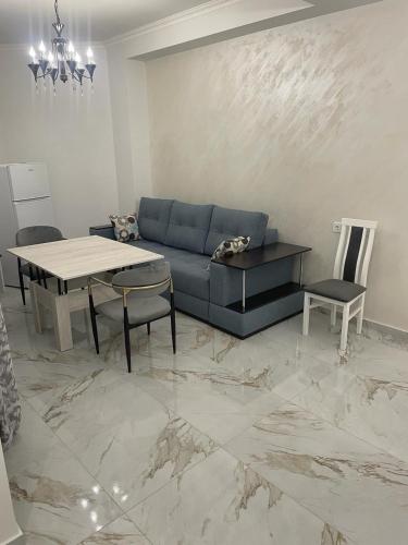 a living room with a blue couch and a table at Apartment in centre of Yerevan in Yerevan