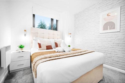 a white bedroom with a large bed and a brick wall at Luxury Birmingham City Centre Apartment - Balcony - Free Wifi & Netflix - Top Rated -126S in Birmingham