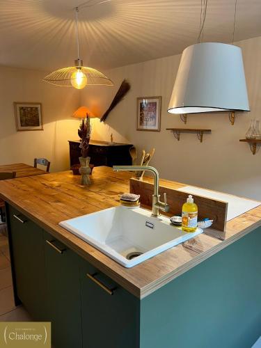 - un comptoir de cuisine avec évier et lumière dans l'établissement L'éco-Domaine du Chalonge, à Héric