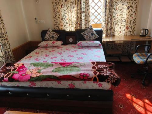 1 dormitorio con 1 cama con manta de flores en Bashaw Residency, Top Rated Family Guest House Near Srinagar Airport, en Srinagar