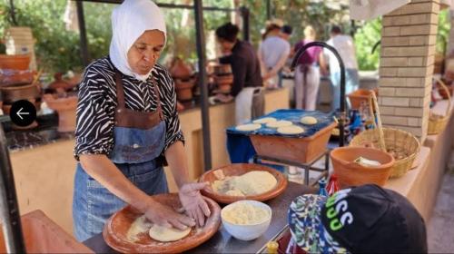 a woman is making food on a table at Sahara Happy Camp in Merzouga