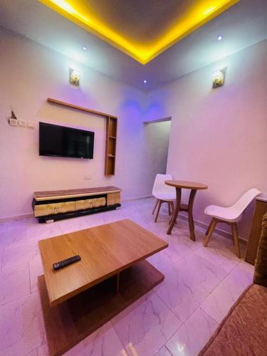 een woonkamer met een tv en een tafel en stoelen bij empire homes service apartment badagry in Magbon