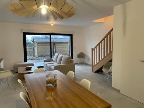 een woonkamer met een tafel en een bank bij Superbe maison neuve proche centre-ville et plage in Neufchâtel-Hardelot