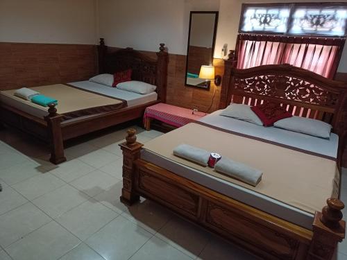 2 Betten in einem Hotelzimmer mit 2 Betten sidx sidx sidx sidx in der Unterkunft Nyoman House Ubud in Ubud