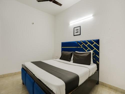 um quarto com uma cama azul e branca num quarto em OYO Happy Home Residency em Nova Deli