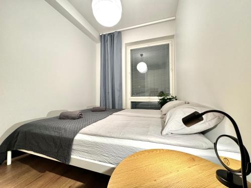 1 dormitorio con 1 cama grande y ventana en Stay with locals at Tripla (room) en Helsinki