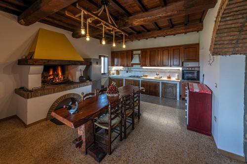 eine Küche mit einem Holztisch und einem Kamin in der Unterkunft Il casale del Mignone in Blera