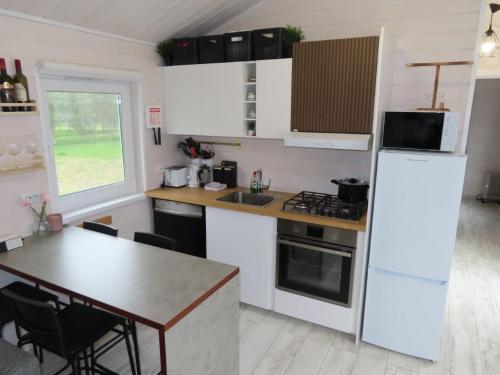 uma cozinha com um frigorífico branco e uma mesa em Eyjabakki 1 em Reynivellir