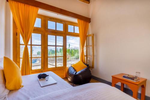 Downtown Hostel Leh في ليه: غرفة نوم بسرير ونافذة كبيرة