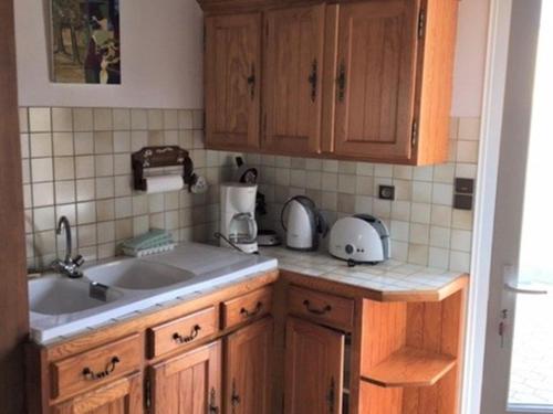 a kitchen with wooden cabinets and a sink at Maison Vieux-Boucau-les-Bains, 4 pièces, 4 personnes - FR-1-379-123 in Vieux-Boucau-les-Bains