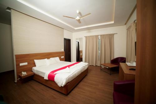 um quarto com uma cama, uma cadeira e uma secretária em Doves Danta Resort, Coorg em Cherambane