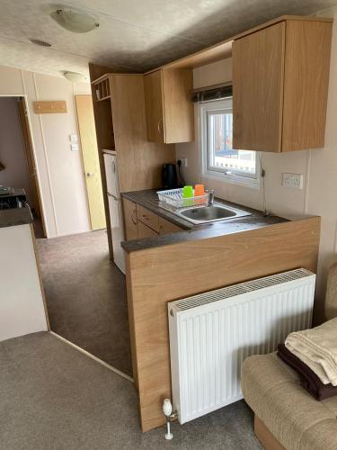 a small kitchen with a sink and a counter at Thistle 83 in Porthcawl